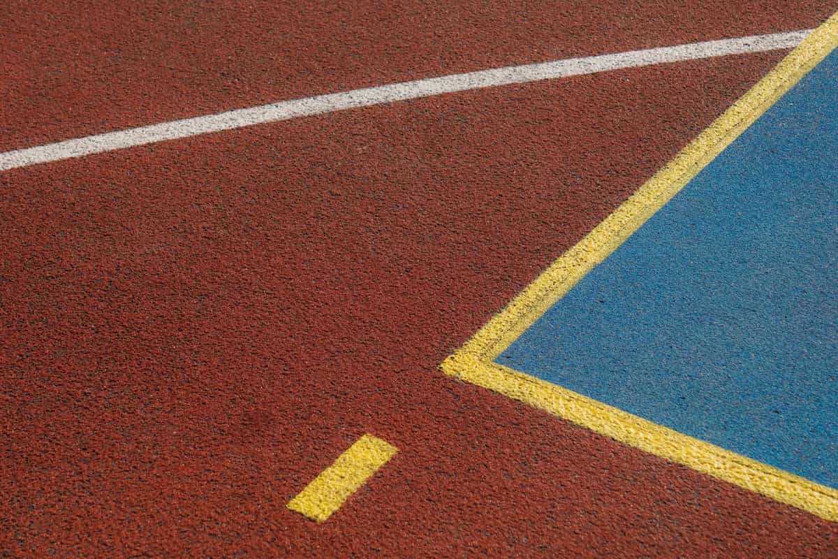 Painted court lines on a textured asphalt basketball court