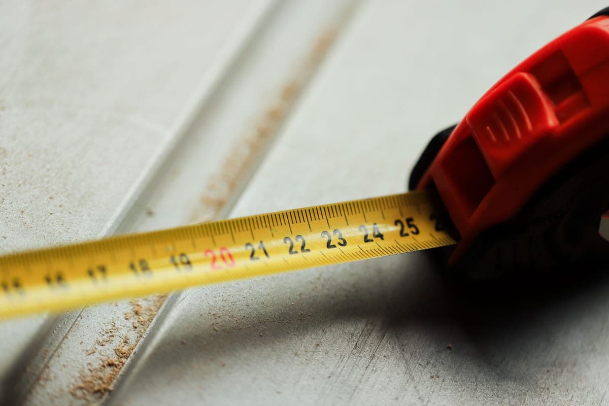 A tape measure extended across a rough construction surface